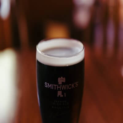 A pint of black liquid with white foam around the rim