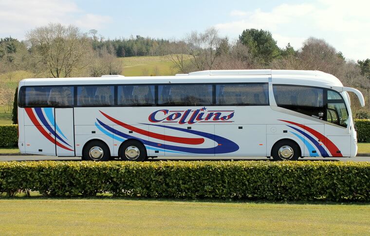 Side view of white coach with blue and red pattern down the side